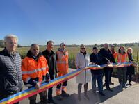 Bild vergr��ern: Vertreter der Baufirmen und der Kreisverwaltung stehen nebeneinander auf der Stra�e und schneiden ein Band zur Er�ffnung der Stra�e durch.